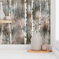 the wallpaper in this room is painted with watercolors and has trees on it