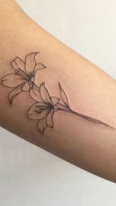 a woman's arm with a flower tattoo on the left side of her arm