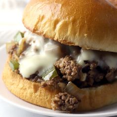 a close up of a sandwich on a plate with meat and cheese in the middle