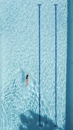 an overhead view of a person swimming in a pool with no one on the side