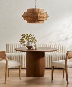 a dining room table with chairs and a basket hanging from the ceiling