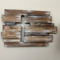 a wooden wall hanging on the side of a white wall