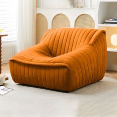 an orange chair sitting on top of a white rug