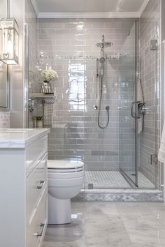 a white toilet sitting next to a walk in shower