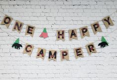 one happy camper banner on a brick wall