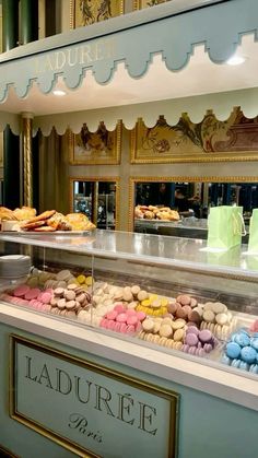 a display case filled with lots of different types of donuts in front of a store