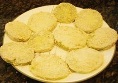 a white plate topped with cookies covered in powdered sugar on top of a granite counter