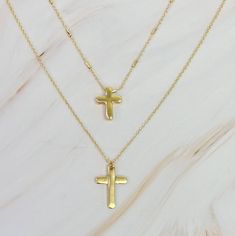 This set of two necklaces features a pretty chain and modern cross design. Versatile and stylish, these necklaces can be worn together for a complementing look or separately to make a statement. Elevate any outfit with this must-have accessory set. Dimensions: approximately 16", 18" chains. Each chain comes with a 3" extender Plated alloy metal Lead and Nickel compliant Everyday Cross Charm Necklace With Clavicle Chain, Adjustable Cross Necklaces With Delicate Chain, Adjustable Cross Necklace With Delicate Chain, Adjustable Delicate Chain Cross Necklaces, Metal Cross Charm Necklace, Adjustable Clavicle Chain Cross Necklace, Dainty Adjustable Cross Necklace, Trendy Cross Necklace With Adjustable Chain, Trendy Cross-shaped Jewelry With Adjustable Chain