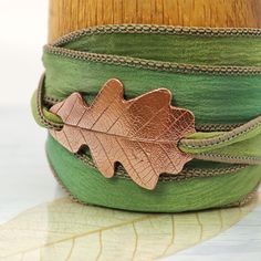 "Last leaf of autumn crunched under their feet. The forest path meandered, never showing them what lay ahead. Just as well they didn't know. They would go through frightening things before the sun suddenly burst out again."  Artisan oak design copper wrap bracelet. The softest silk ribbon wrap bracelet with a decorated copper slide.  I have created the focal by hand from recycled copper in metal clay form. After firing the clasp is pure copper.  The copper is shaped as an oak leaf. The oak is an Silk Wrap Bracelets, Forest Path, Leaf Bracelet, Ribbon Wrap, Autumn Leaf, Hand Dyed Silk, Oak Leaf, Ancient Symbols, Craft Accessories