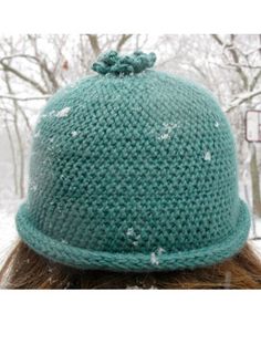 a woman wearing a green knitted hat in the snow