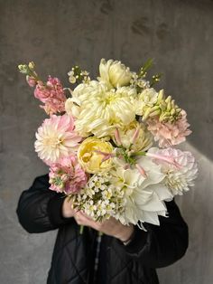 a woman holding a bouquet of flowers in her hands