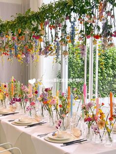 a long table is set with flowers and candles for an elegant dinner or party event