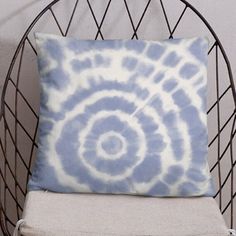 a blue and white pillow sitting on top of a chair