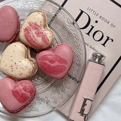 three heart shaped macaroons on a plate next to a book