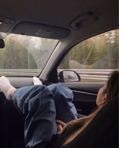 two people sitting in the back seat of a car with their feet on the passenger's headrest