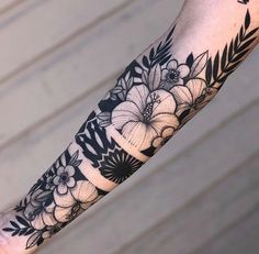 a woman's arm with black and white flowers on the inside of her arm