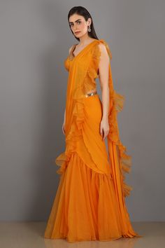 Orange frill chiffon skirt with organza ruffle drape. Comes with silk embroidered blouse and belt.
Component: 4
Embroidered
Neckline: Sweetheart
Sleeve Length: Sleeveless
Fabric: Chiffon, Organza, Silk
Color: Orange
Embroidered blouse and belt
Separate ruffle drape - Aza Fashions Orange Chiffon Saree, Orange Chiffon, Ruffle Saree, Drape Saree, Blouse For Women, Embroidered Neckline, Chiffon Ruffle, Chiffon Saree, Chiffon Skirt