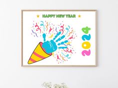 a happy new year poster hanging on the wall next to a vase with flowers in it