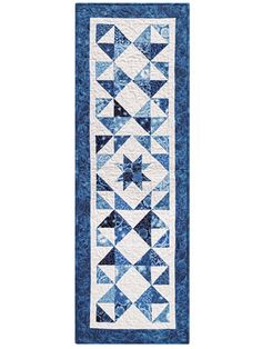 a blue and white quilted runner with triangles on the front, along side it