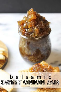 a jar filled with sweet onion jam next to crackers