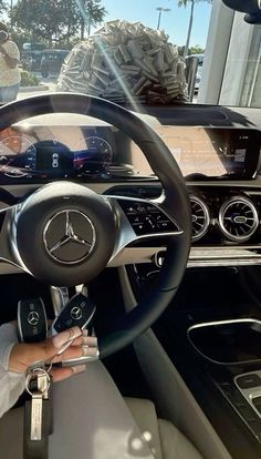 a man sitting in the driver's seat of a car holding a steering wheel