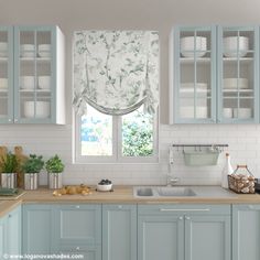 a kitchen with light blue cabinets and white counter tops, along with a window covered in roman shades