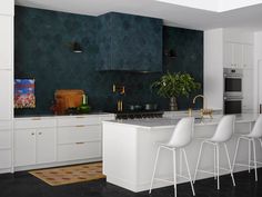 a kitchen with white cabinets and bar stools