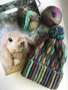 two balls of yarn are next to a rabbit