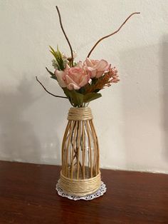 a vase filled with pink roses sitting on top of a wooden table