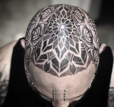 a man's head with tattoos on it and an intricate design in the middle