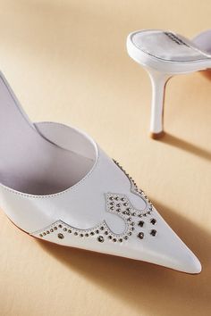 The Jeffrey Campbell Bite Me Mules offer edgy sophistication, featuring a sleek design, bold metal embellishment, and a pointed-toe silhouette. | Bite Me Mules by Jeffrey Campbell in White, Women's, Size: 6, Leather at Anthropologie Formal Embellished Heels With Pointed Toe, Embellished Pointed Toe Heels, Pointed Leather Heels For Party, Glamorous Pointed Toe Heels With Metal Feet, Chic Embellished Pointed Toe Heels, Leather Heels With Rhinestones For Events, Clothing Collage, Wedding Wardrobe, Bite Me