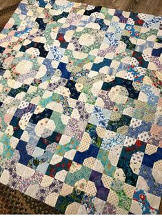 an old quilt is laying on the floor with it's blue and white colors