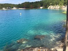 the water is crystal blue and there are rocks on the shore