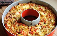 a casserole dish with cheese and vegetables in it on a wooden table top