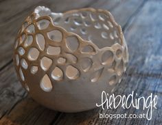 a white vase sitting on top of a wooden table