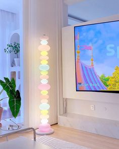 a flat screen tv mounted to the side of a wall in a living room next to a potted plant