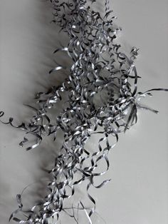 a bunch of silver streamers hanging from the side of a wall