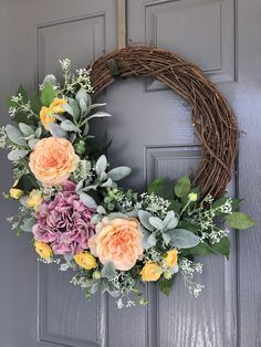 a wreath with flowers is hanging on the front door to give it a touch of color