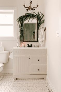 a bathroom with a sink, toilet and mirror in it's centerpieces