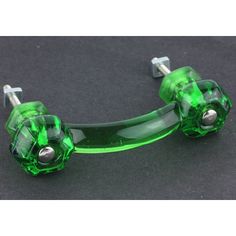 an image of a green glass handlebars on a black surface with screws