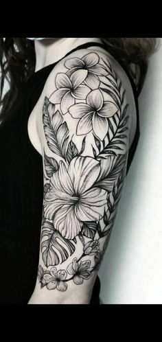 a woman's arm with flowers and leaves on the back of her shoulder, which is