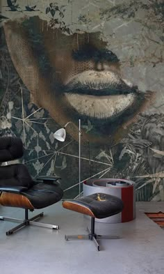 a chair and ottoman in front of a wall with an image of a woman's face on it