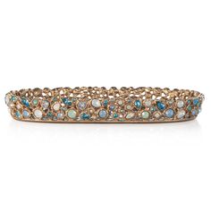 an antique bracelet with blue and white stones in gold tone, on a white background