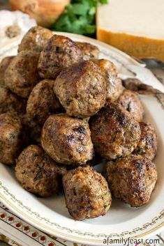 a white plate topped with meatballs on top of a table