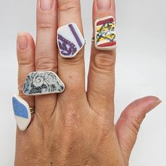 a person's hand with three different rings on it