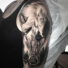 a woman's arm with a horse and trees on it