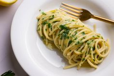 a white plate topped with pasta covered in parsley