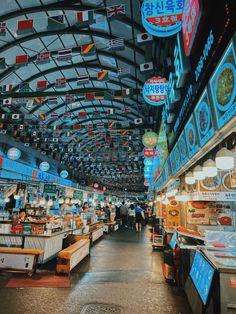 the inside of a grocery store with flags hanging from the ceiling