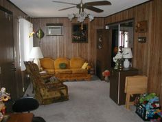 a living room filled with furniture and lots of clutter on top of carpeted flooring