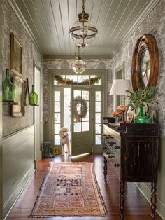 a dog is standing in front of the door to a room with a rug on the floor